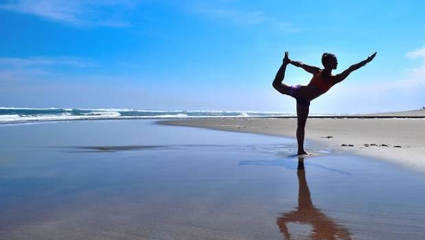 Girl doing yoga on the beach at Bali retreat