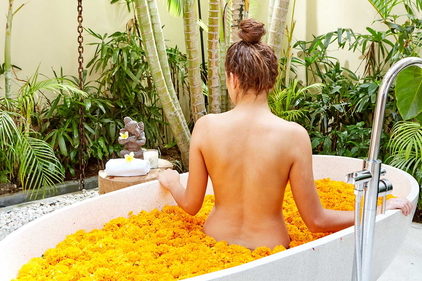 Woman relaxing in flower bath at Bali wellness retreat