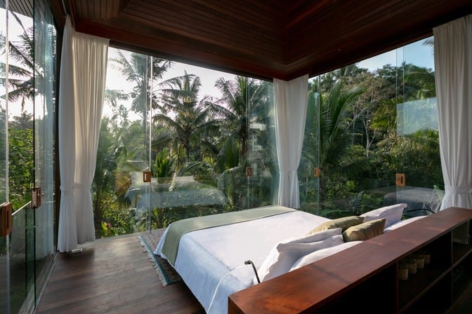 bedroom with glass walls overlooking tropical garden at the Ubud Bliss Sanctuary, Bali